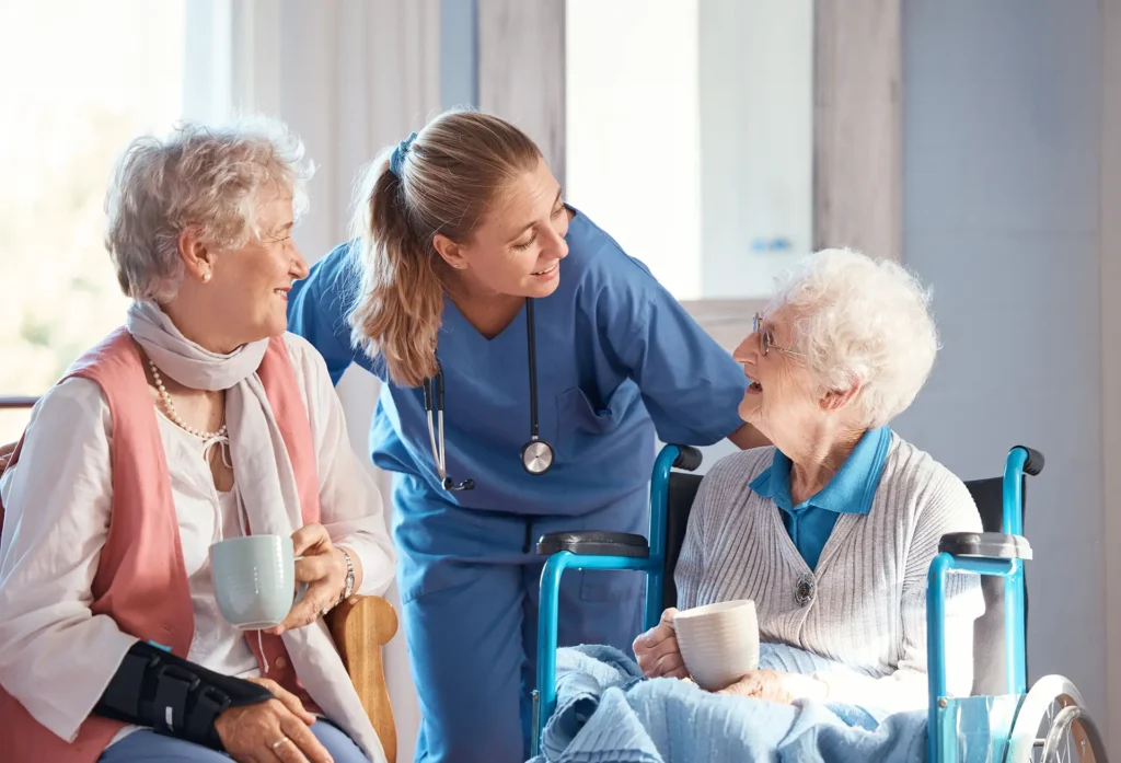 Symbolbild: Pflegerin mit zwei Patienten die sich herzlich unterhalten